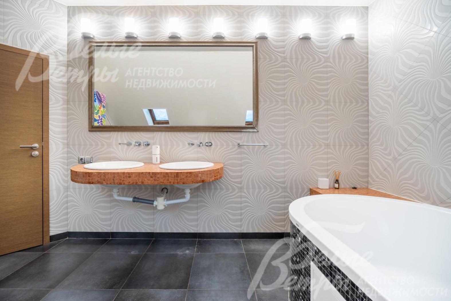 Пол выложен контрастной крупной тёмной плиткой с матовой поверхностью, двойная раковина - на подвесной конструкции