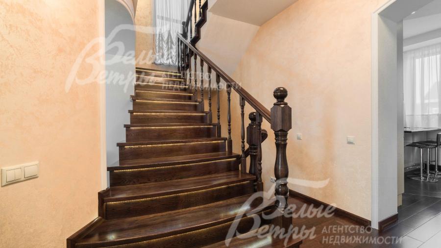 Красивый, широкий и удобный лестничный марш из массива темного дуба с подсветкой ступеней