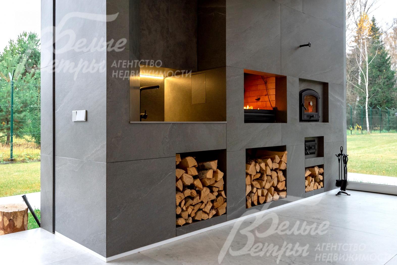 На террасе очарование живого огня в печи гармонично сочетается с эстетикой пространства