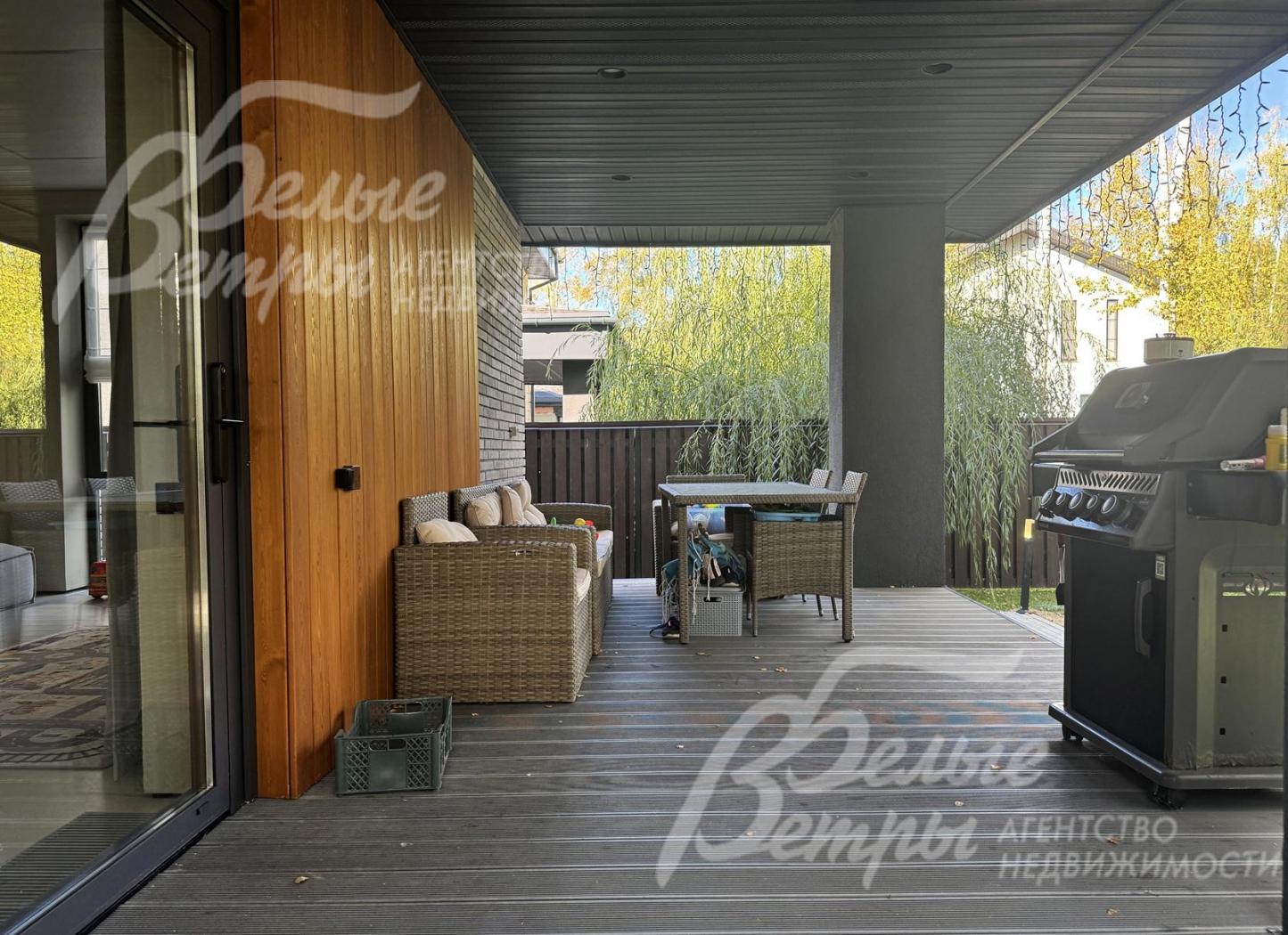 На террасе установлена садовая мебель и мангал