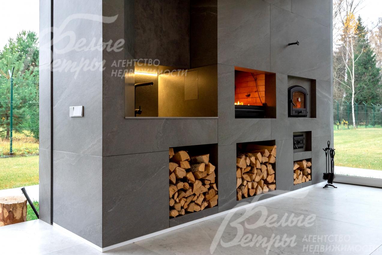 На террасе очарование живого огня в печи гармонично сочетается с эстетикой пространства