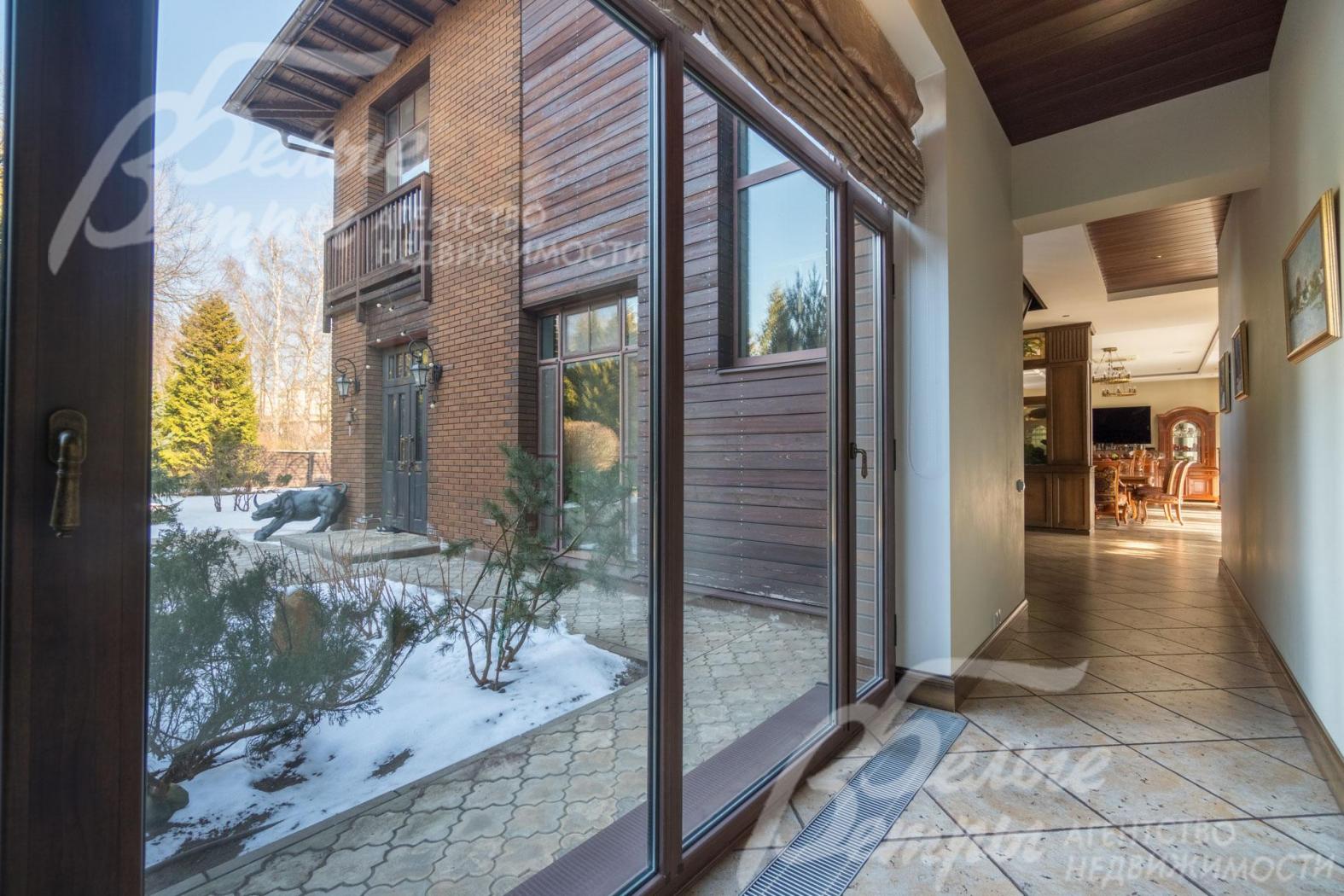 Панорамное остекление в холле-коридоре с выходом на участок. Из холла открывается красивый вид на участок