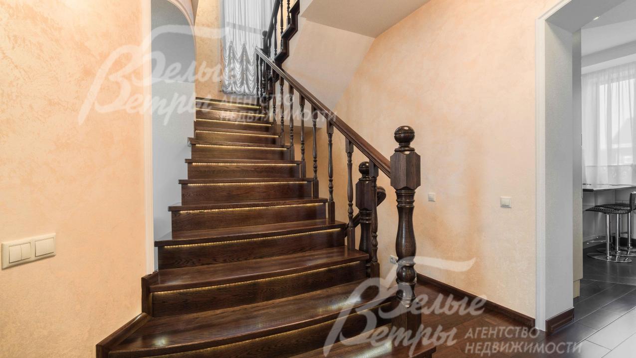 Красивый, широкий и удобный лестничный марш из массива темного дуба с подсветкой ступеней