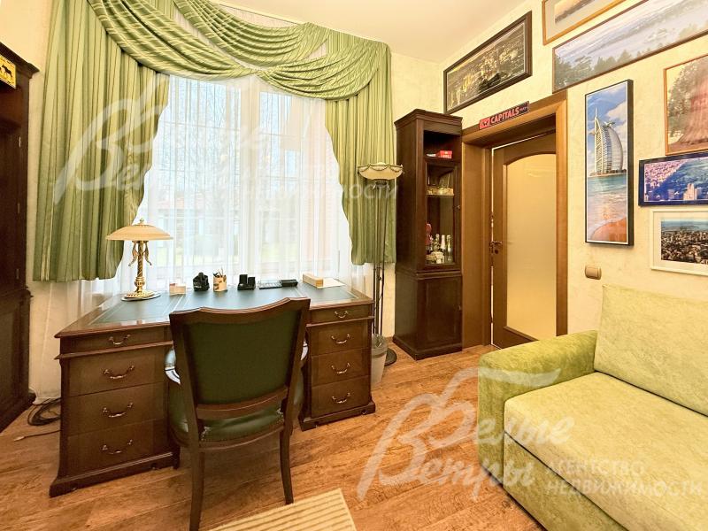 Одна из спален оборудована под кабинет, установлена классическая мебель из массива дерева и диван