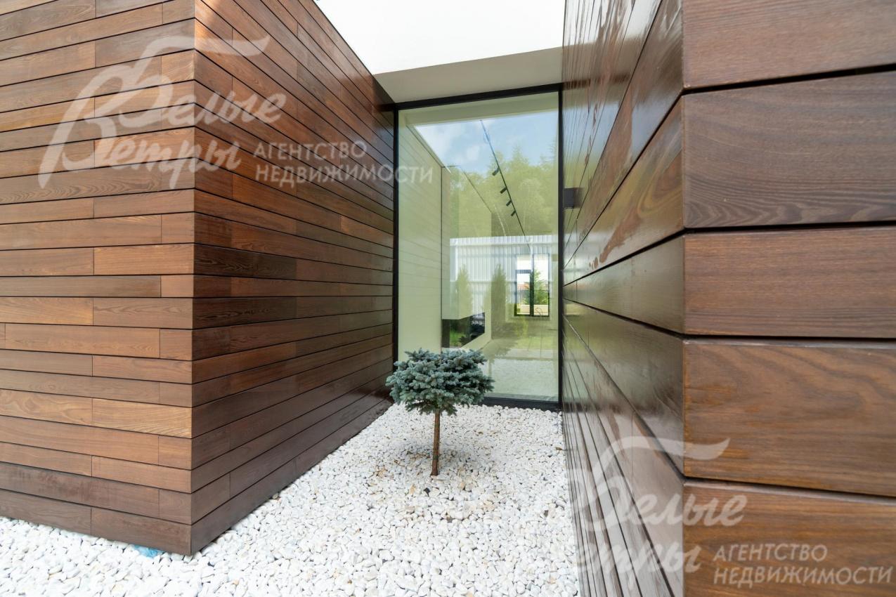 Придомовая территория оформлена стильными ландшафтными композициями