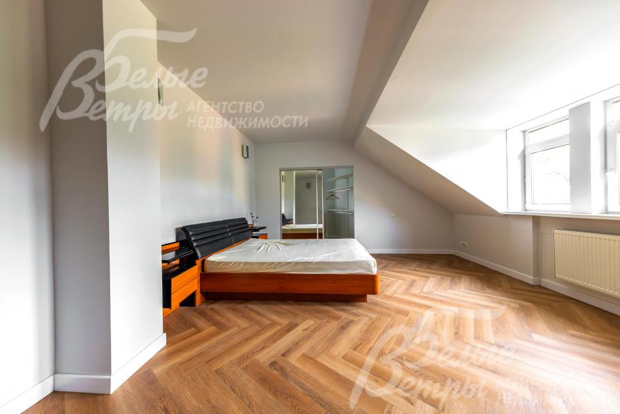 Одна из спален на втором этаже с кроватью и гардеробной