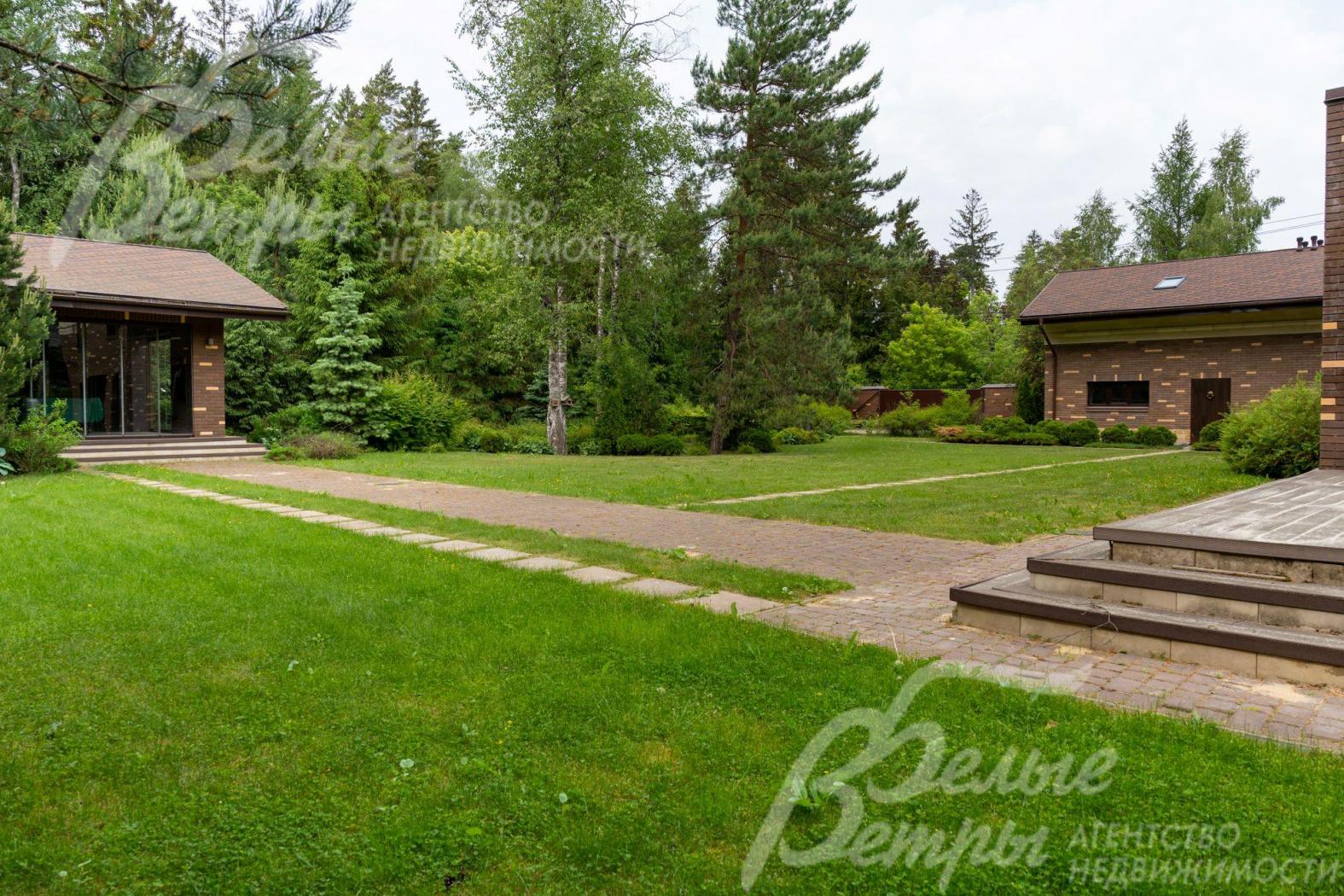 На участке с естественным газоном, с дорожками-тропинками из натурального камня, сделано освещение. 