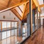 Холл второго этажа над гостиной со вторым светом: отделка подчёркивает природную тематику интерьера