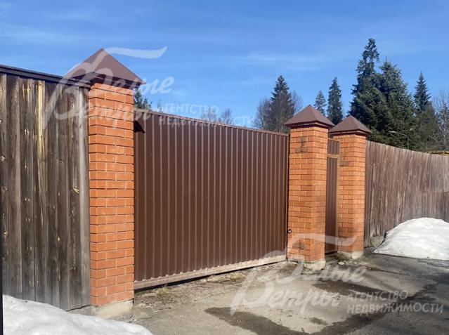 Въезд на участок оформлен кирпичными столбами, установлены откатные ворота