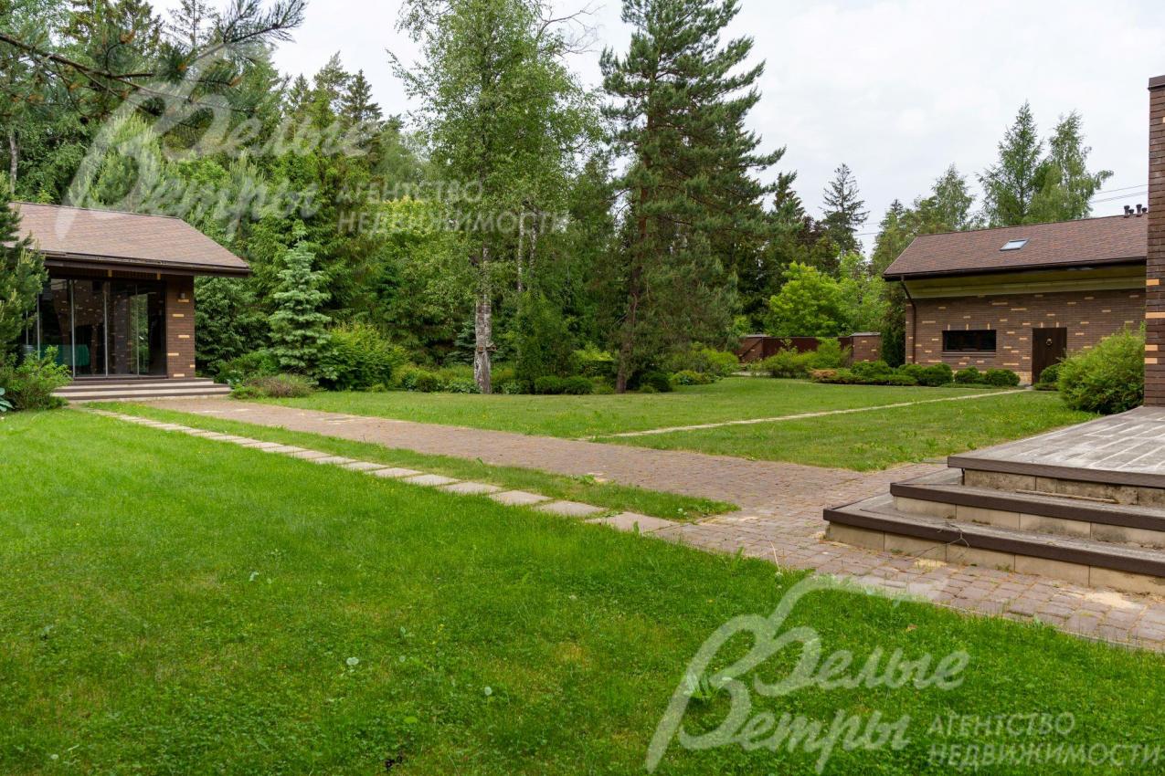 На участке с естественным газоном, с дорожками-тропинками из натурального камня, сделано освещение. 