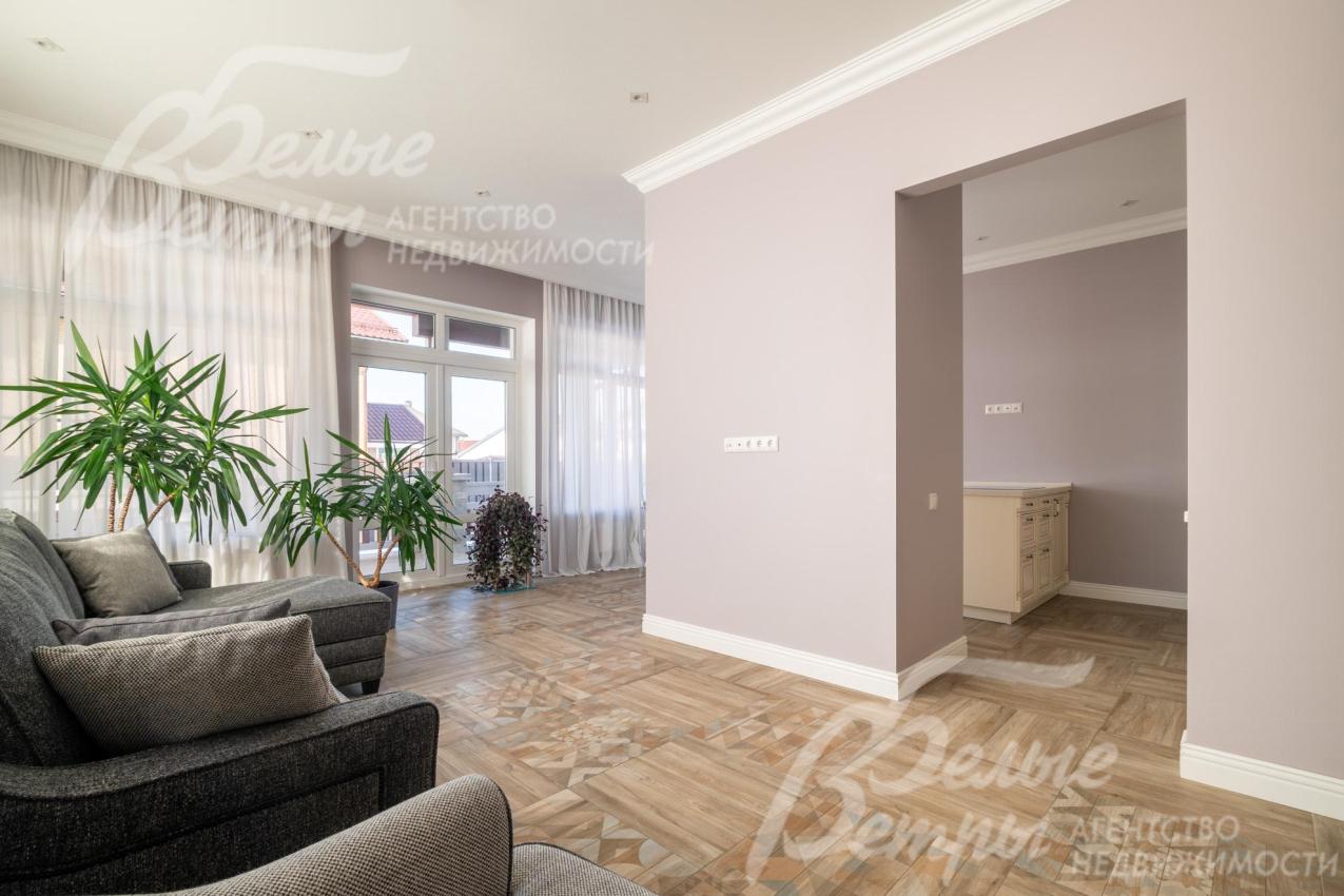 Зоны гостиной и кухни-столовой разделяет перегородка с порталом, на полу в этих помещениях уложен керамогранит с водяными полами