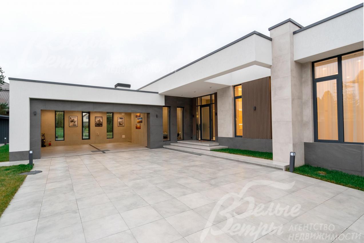 Территория перед центральным входом и гаражом выложена светлым керамогранитом