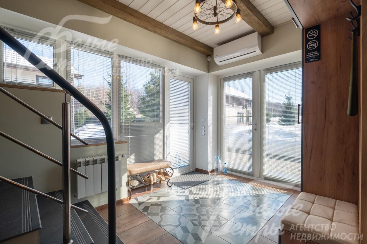 Вход в дом - через просторную прихожую с панорамными стеклянными дверями (за лестницей есть чемоданная комната)