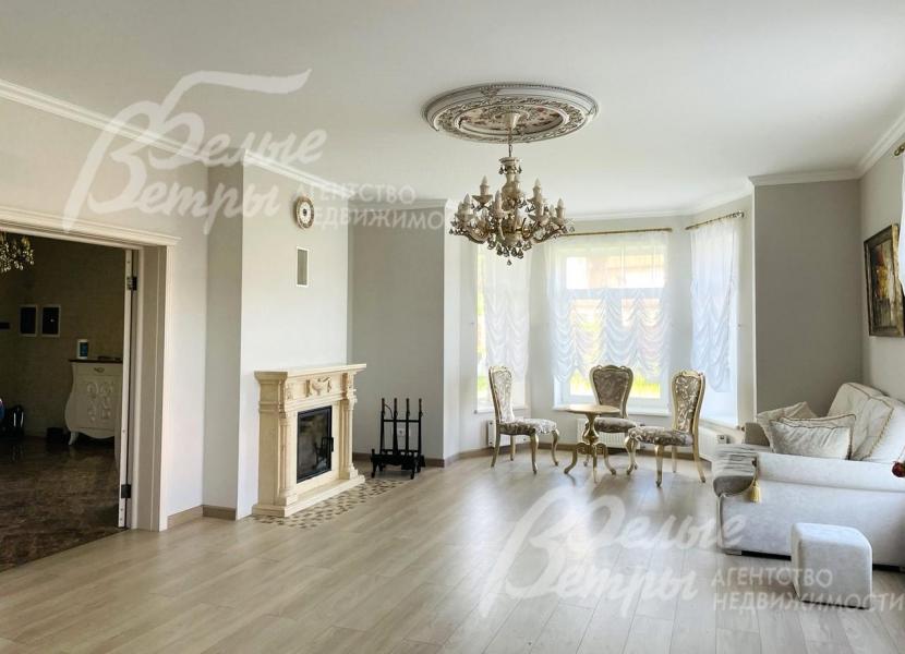 Зона гостиной с камином, отделанным мрамором.