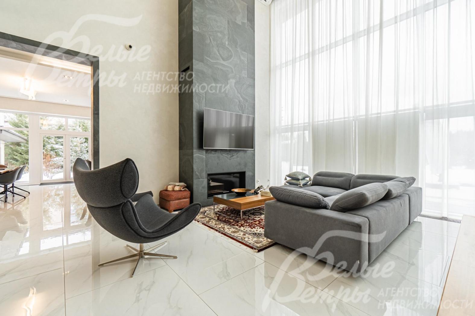 В гостиной находится мебель BoConcept: большой диван, кресло, журнальный столик