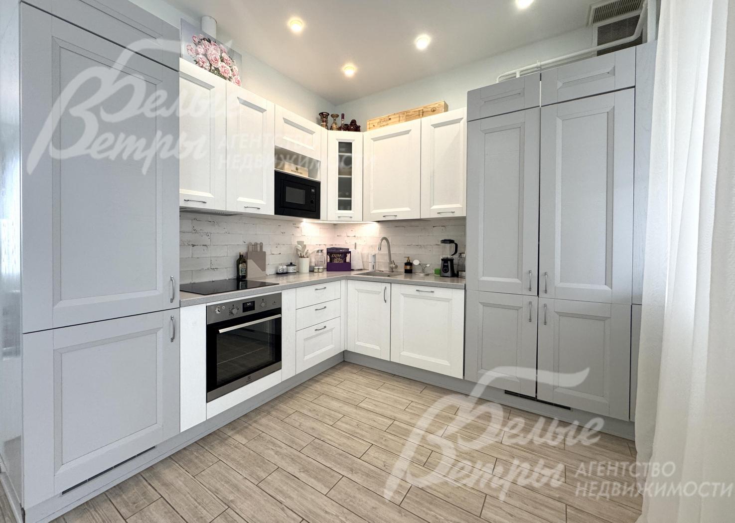 На кухне - встроенные варочная панель, вытяжка, холодильник (скрыт за дверцами)