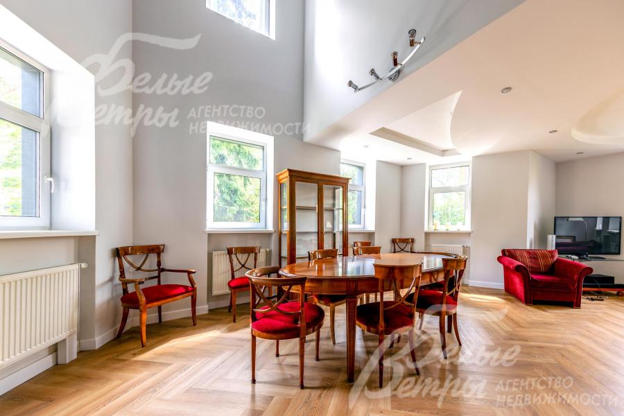 В гостиной-столовой установлена обеденная группа, напротив камина - диванная группа