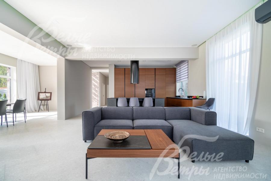 Интерьер кухни-гостиной и столовой оформлен в светлых тонах с акцентной мебелью