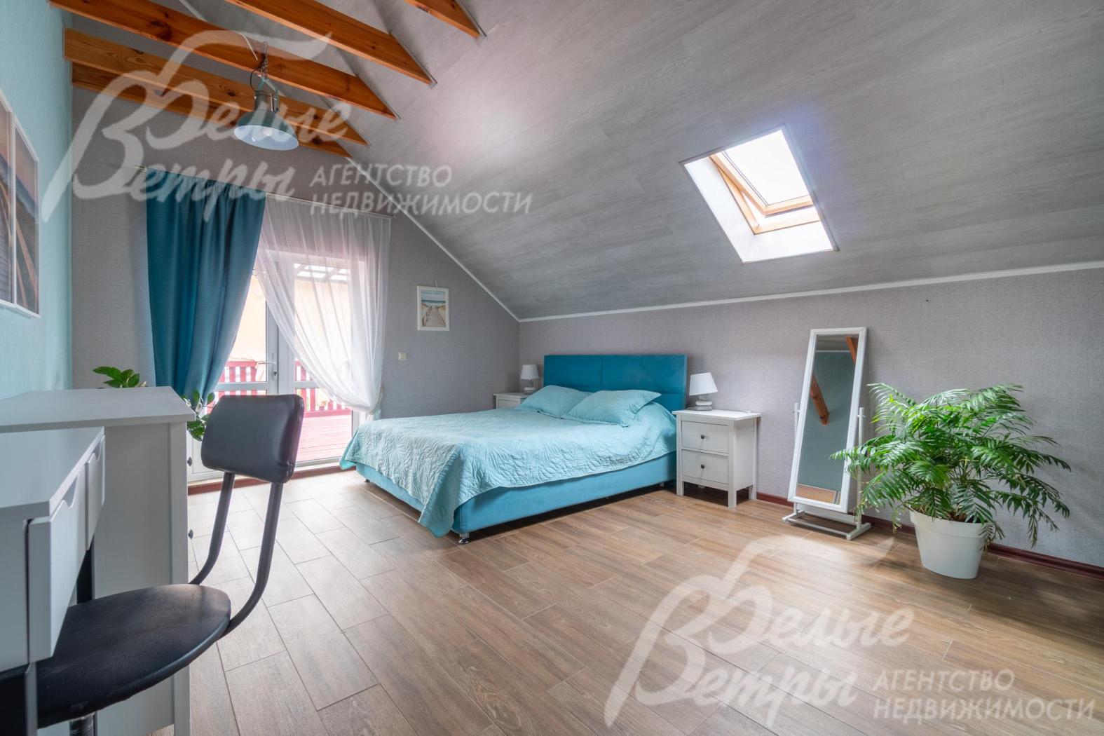 Одна из спален на втором этаже с мансардным окном и выходом на просторную крытую террасу 41,5 кв.м