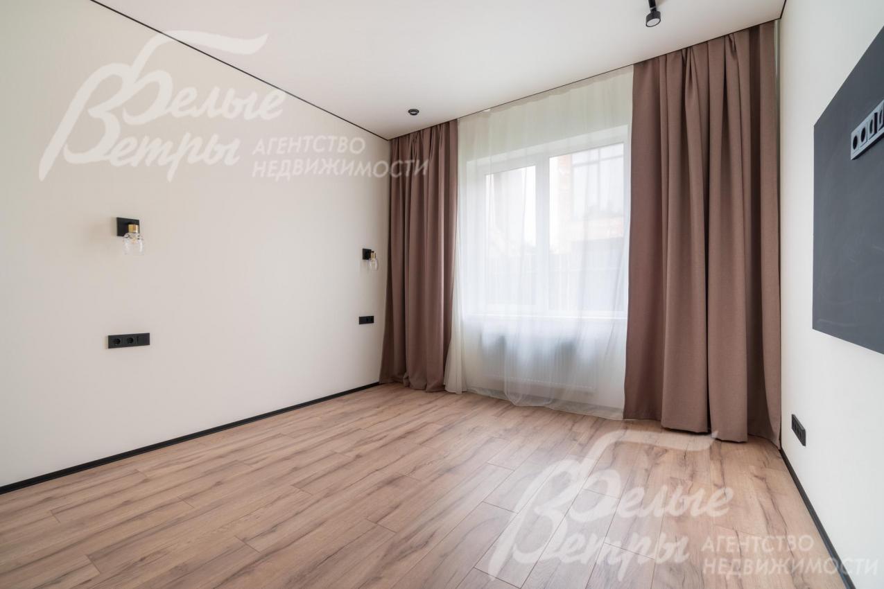 В мастер-спальне - большое окно, оформленное шторами, и декоративная панель под телевизор