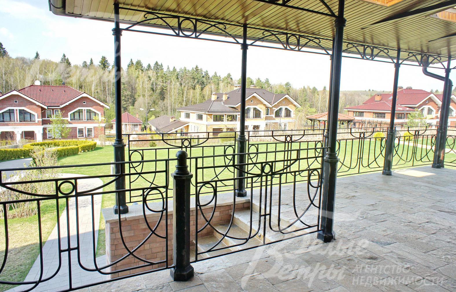 Терраса с коваными перилами и видом на участок