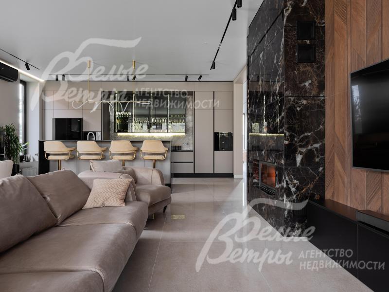 Единое функциональное пространство гостиной и кухни, зонированное островом