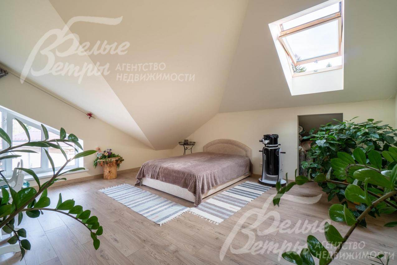 Просторная светлая спальня на мансардном этаже