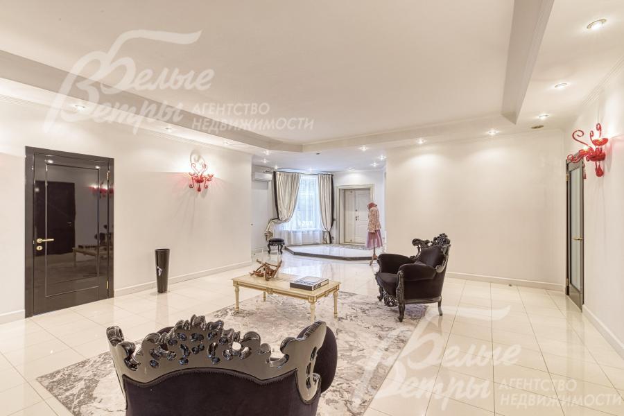 Светлый холл на первом этаже с дизайнерским интерьером и входом-подиумом