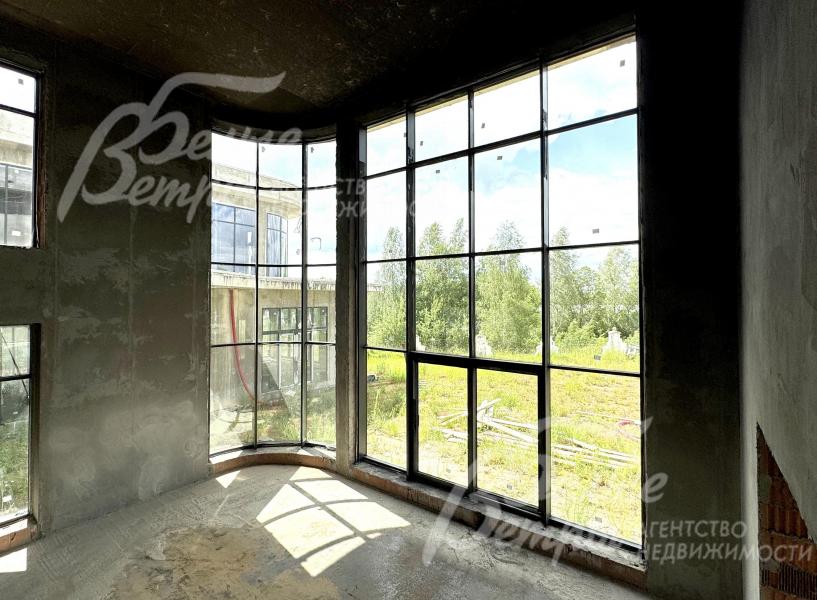 В гостиной - вертикальное остекление от пола до потолка с эркерным окном: открывается живописный вид на участок и в сторону озера