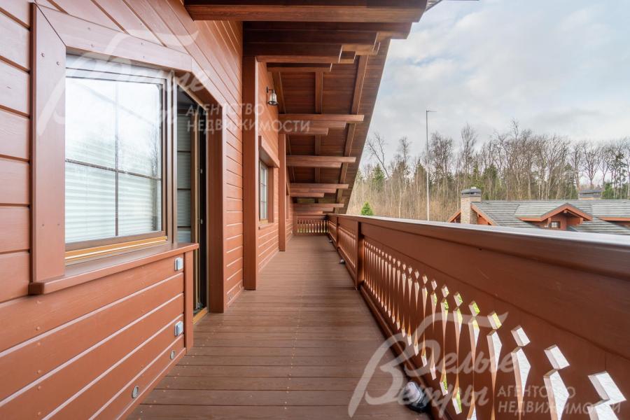 С просторной террасы при спальне с изящным резным ограждением и массивными балками под крышей открывается живописный вид на окружающую местность