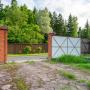 Территория участка огорожена деревянным забором с воротами из профлиста