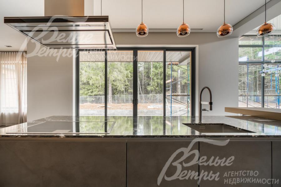 Кухонный остров с раковиной и видом на лес